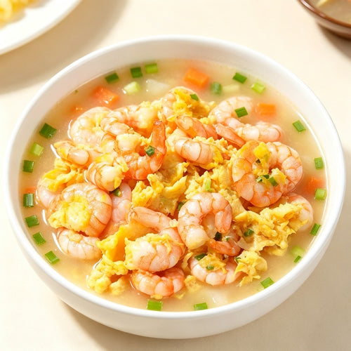 Shrimp scrambled with egg in a bowl with green peas, carrot dice and scallion