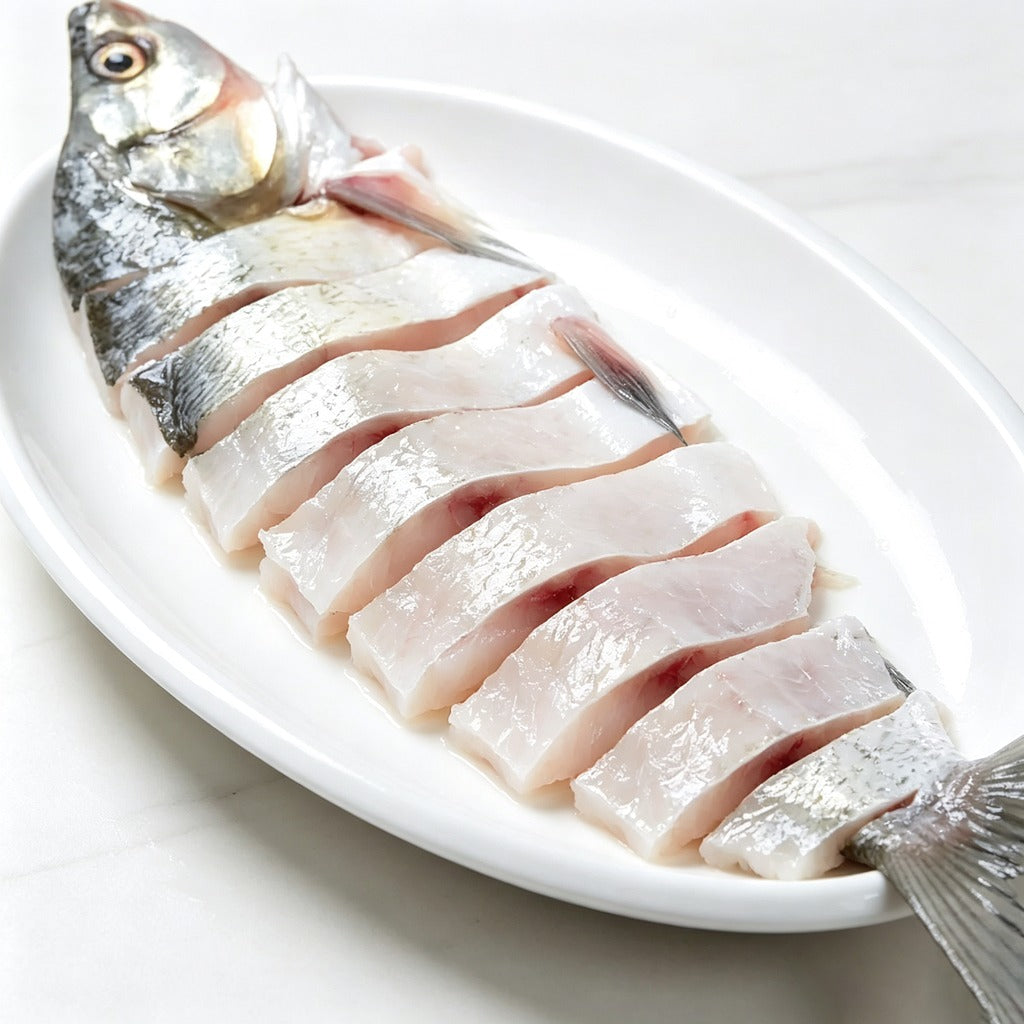 Raw pre-sliced whole fish on a white plate, silver skin and white flesh on show